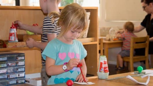 Child applying Clag glue to paper
