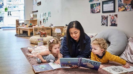 Educator reading to two children at Guardian Margaret street