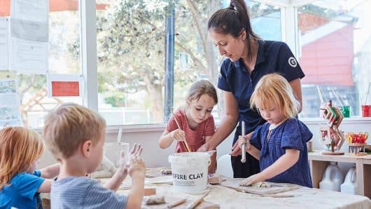 Children painting with educator inside at Maroubra East