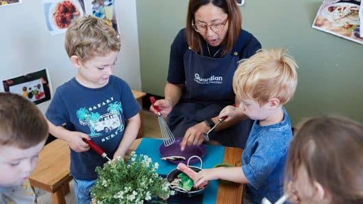 Educator playing with cooking equipment with children Maroubra East