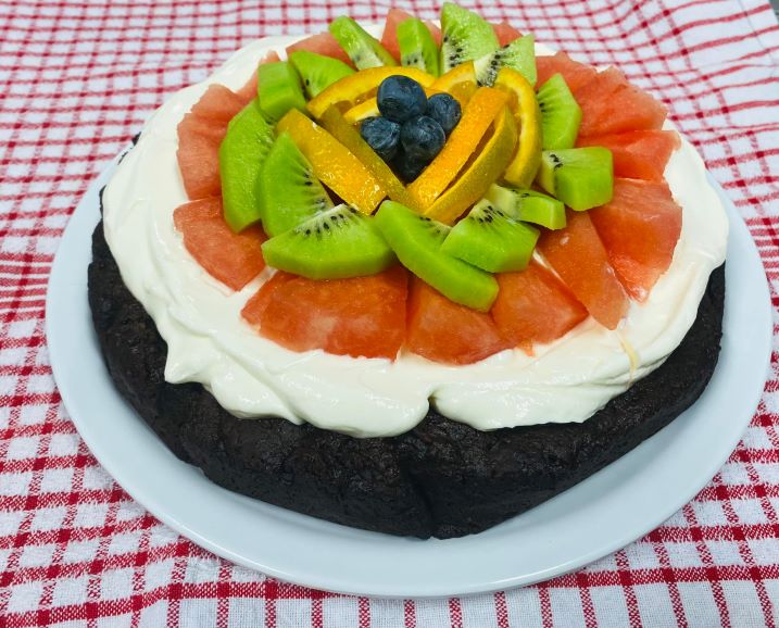 Bright coloured chopped fruits on top of chocolate biscuit base.